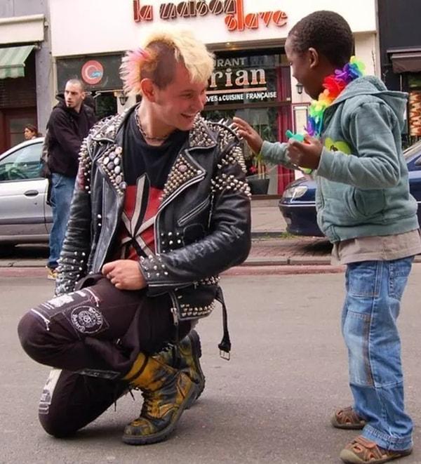 19. Punk bir adam, Gay Pride sırasında bir çocuğun ceketindeki sivri uçlu metallere dokunmasına izin veriyor.