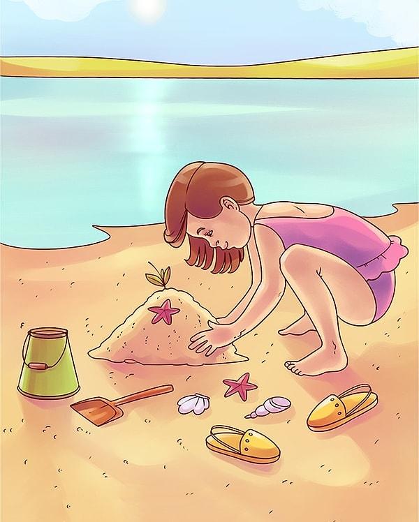9. Plajda kumda oynayan bir kız çocuğu