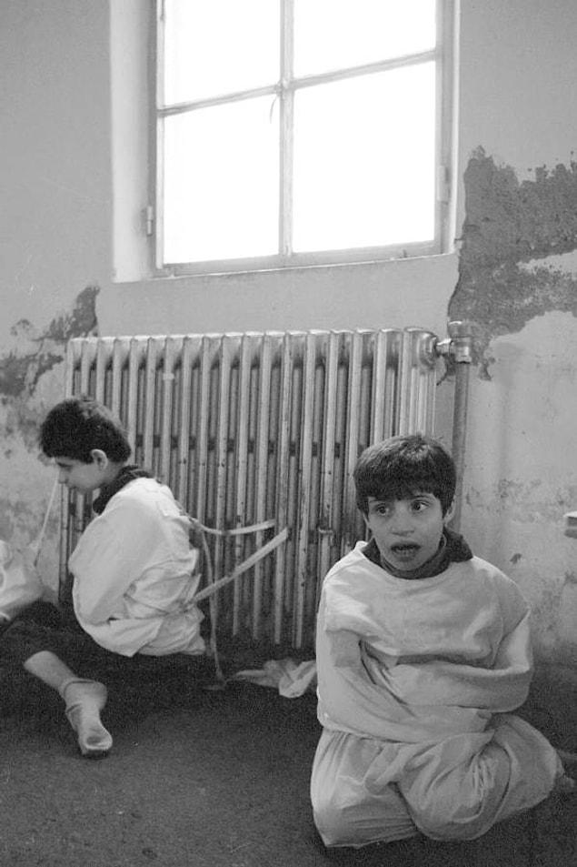 2. Child patients sit bound and tied to a radiator inside the psychiatric hospital at Deir el Qamar, Lebanon in 1982.