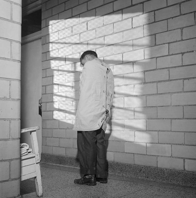 13. A patient stands in a straightjacket inside Ohio's Cleveland State Mental Hospital in 1946.