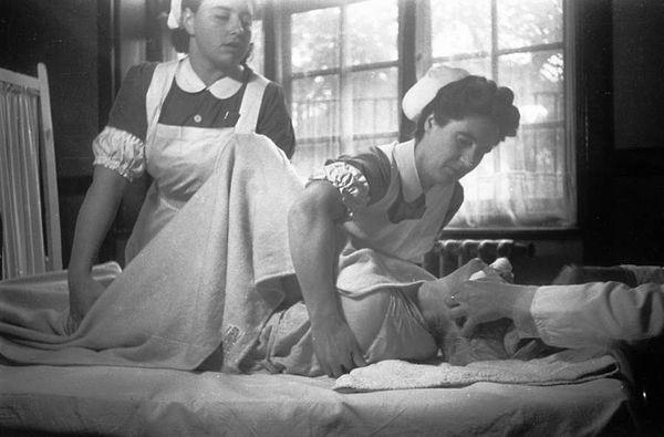 14. Nurses hold down a patient receiving electroshock treatment at a facility in England on November 23, 1946.