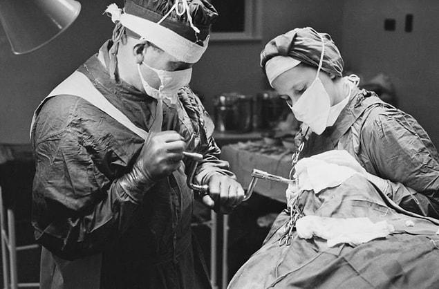 15. A surgeon uses a brace and bit to drill into a patient's skull before performing a lobotomy at a mental hospital in England, November 1946.