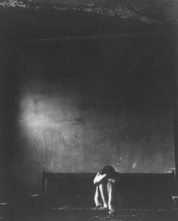 18. A patient sits alone in a dark room inside Ohio's Cleveland State Mental Hospital on February 3, 1955.
