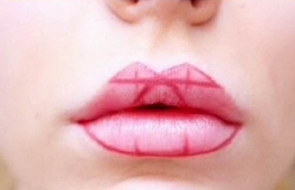 3. Начинаем прорисовать границы губ. Сначала отметьте середину треугольников и прочертите две линии вниз. Затем подведите черту под треугольниками, там, где кончается дуга Купидона. После обведите карандашом контур нижней губы.