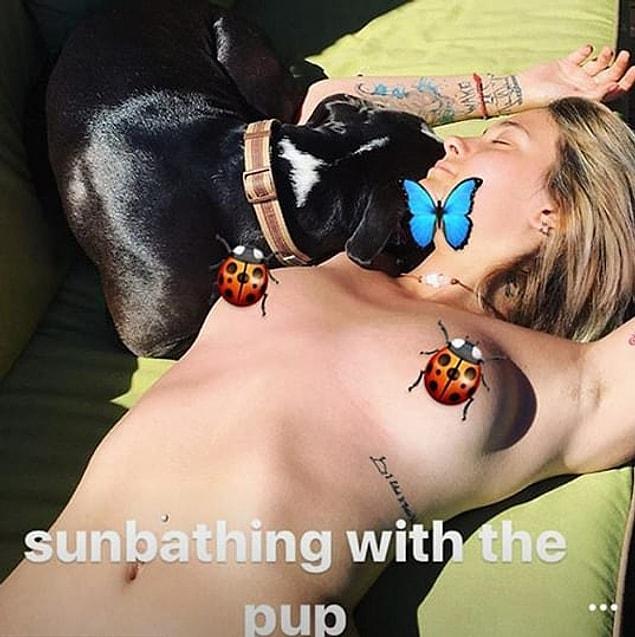 This is the photo of Paris sunbathing with her dog.