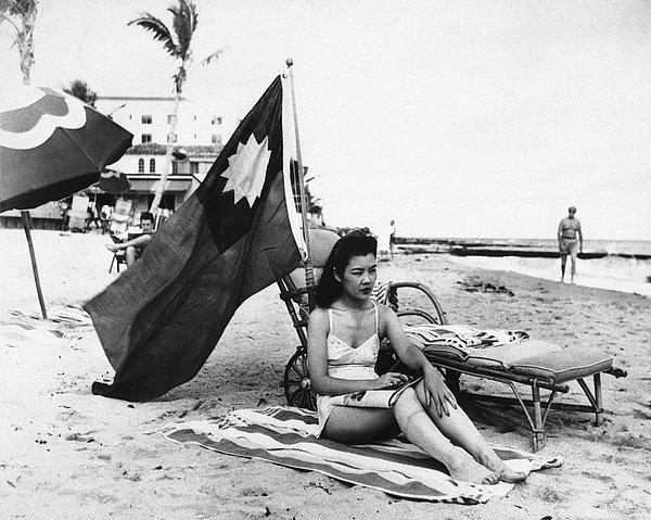1. Japonya tarafından Pearl Harbor'a yapılan saldırı sonrası Japon sanılmaması için kumsala getirdiği Çin bayrağı ile güneşlenen Çinli bir kadın, 1941.