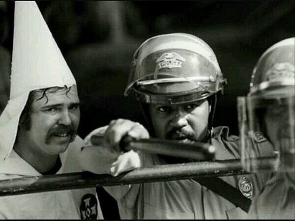 20. Siyahi karşıtı aşırı faşist bir örgüt olan Ku Klux Klan üyesini protestoculardan koruyan siyahi bir polis memuru, 1983.