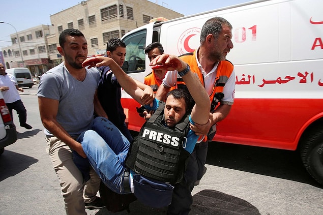 12. Batı Şeria'nın Nablus şehrindeki Hawara kontrol noktasında Filistin ve İsrail vatandaşları arasındaki çatışmalarda yaralanan bir fotomuhabir, 18 Mayıs.
