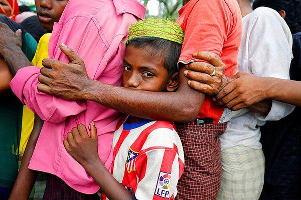 10. Bangladeş'te bir mülteci kampında yiyecek sırasında bekleyen insanlar ve arada sıkışmış küçük bir çocuk, 31 Mayıs.