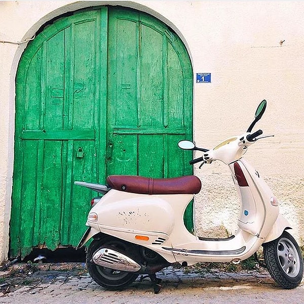 6. Снимок миловидного мопеда или мотоцикла на фоне цветной двери