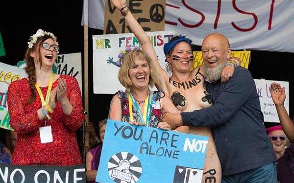 4. Festivalin kurucusu Michael Eavis sahnede üstsüz feminist protestocular, Beyaz Kurdela Birliği ve Avaloniyen Korosu ile birlikte.