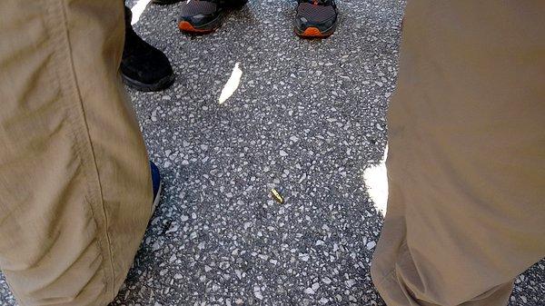 Kılıçdaroğlu'nun 10 metre önünde yerdeki tabanca mermisinin fark edilmesi üzerine polisler, hemen etrafını çevirip önce fotoğrafını çekti.