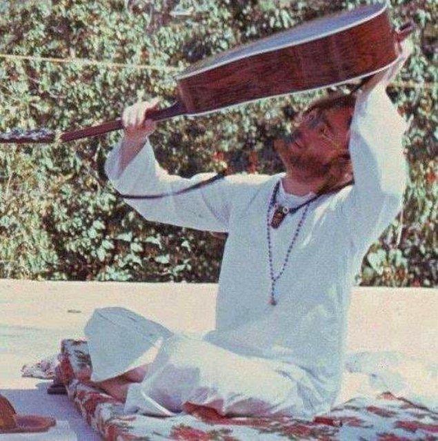 18. Gitarının içine düşürdüğü penasını çıkarmaya çalışan John Lennon. Hindistan, 1968.