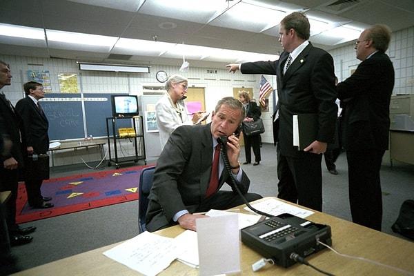 2. George Bush'un asistan yardımcısı Dan Bartlett, Başkan Bush yeni güvenlik bilgilerini dinlerken ona haberleri gösteriyor.