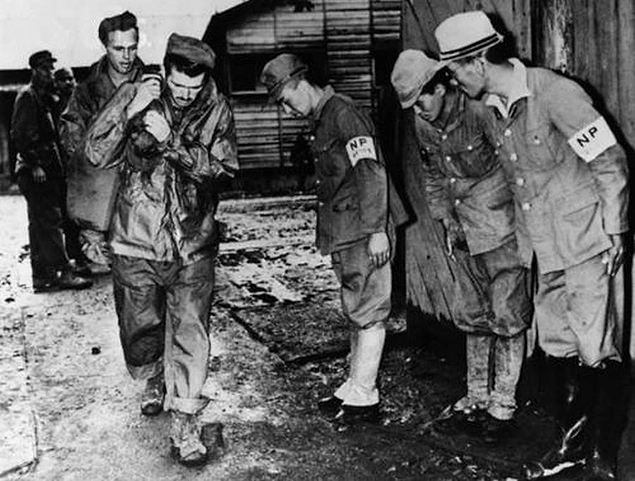 Savaşta teslim olan Japonya'nın askerlerinin, serbest bıraktıkları ABD'li esirlerin önünde eğilmesi, 1945.