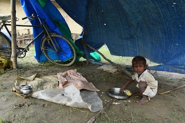 22. Nepal'in başkenti Kathmandu'nun 200 km doğusunda yapılan barınakta bir çocuk yemek yiyor.