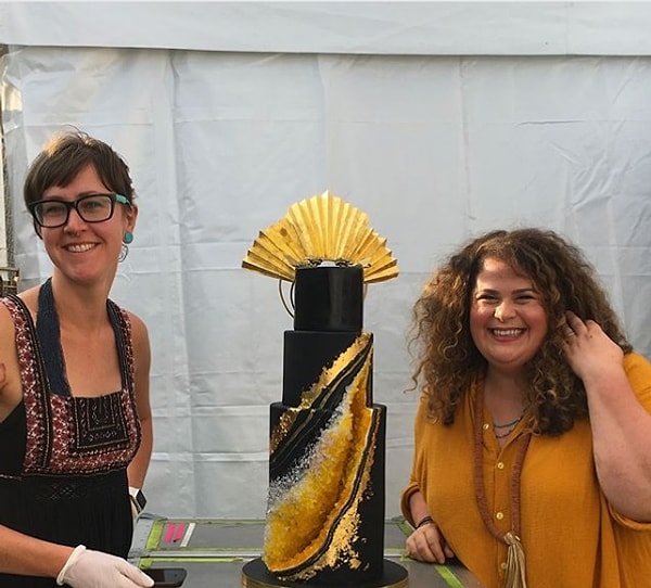 В среду владельцы магазина "Cake Life Bake Shop" в Филадельфии на своей страничке в Instagram поделились фотографией многоуровневого черно-золотого торта с жеодой в кристаллах, который выглядит так, будто он идеально подходит для королевы.