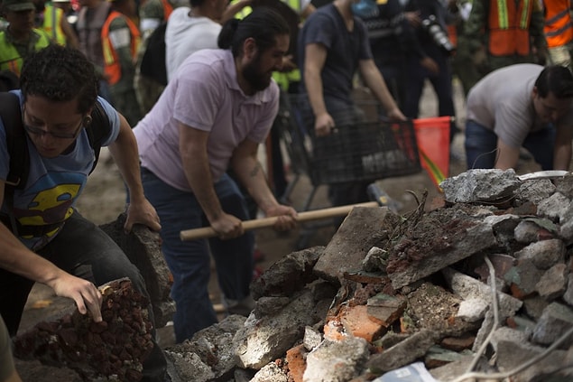 Gönüllüler moloz yığınlarını çıplak elle kaldırarak aşağıdaki insanları kurtarmaya çabalıyor...