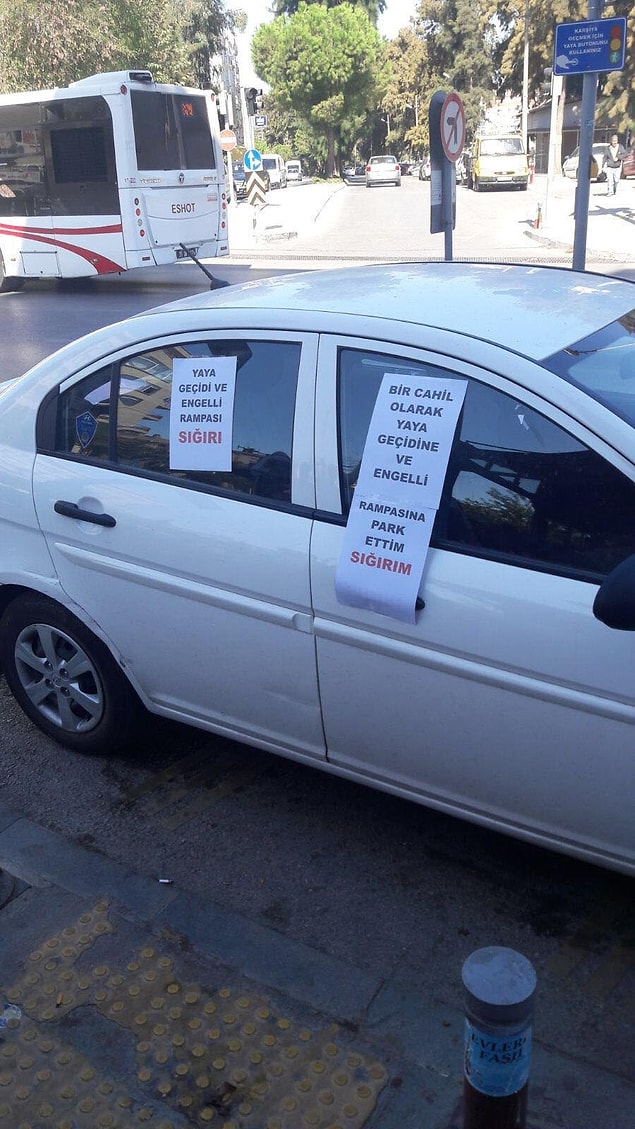 Otomobilin üzerine 'Bir cahil olarak yaya geçidi ve engelli rampasına park ettim, sığırım' ve 'Yaya geçidi ve engelli rampası sığırı' yazıları yapıştırıldı.