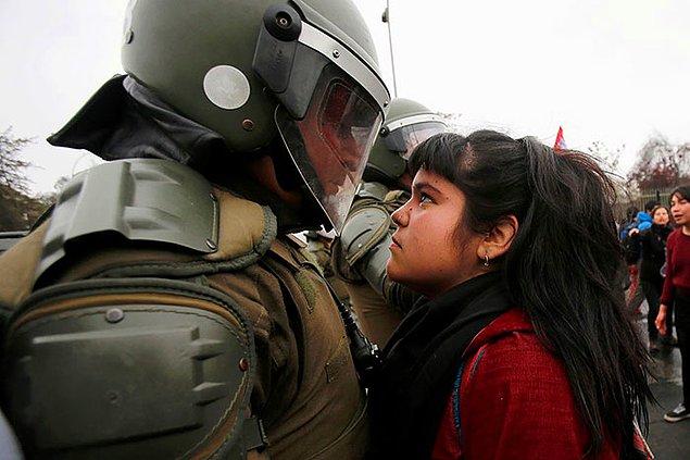 6. Şili'de yapılan 1973 tarihli askeri darbenin hatırlandığı protestoda çevik kuvvet polisine korkusuzca bakan kız..