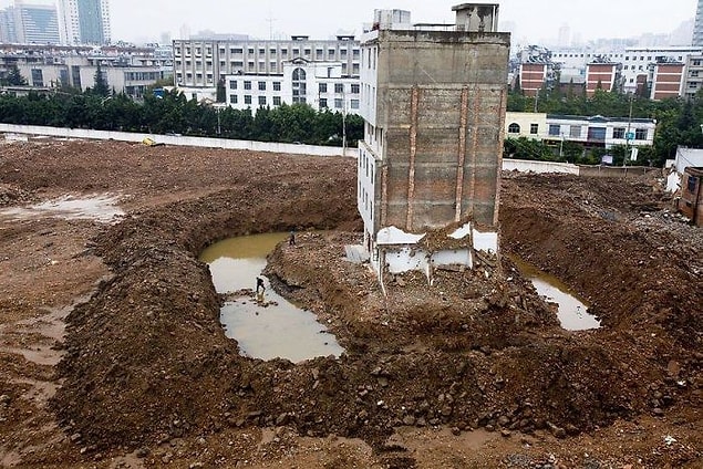 22. Kunming, Çin'de bulunan dairenin kiracıları her gün bir hendek aşmak zorunda, çünkü müteahhitler onları çıkmaya zorlamak için bu çukuru kazdılar.