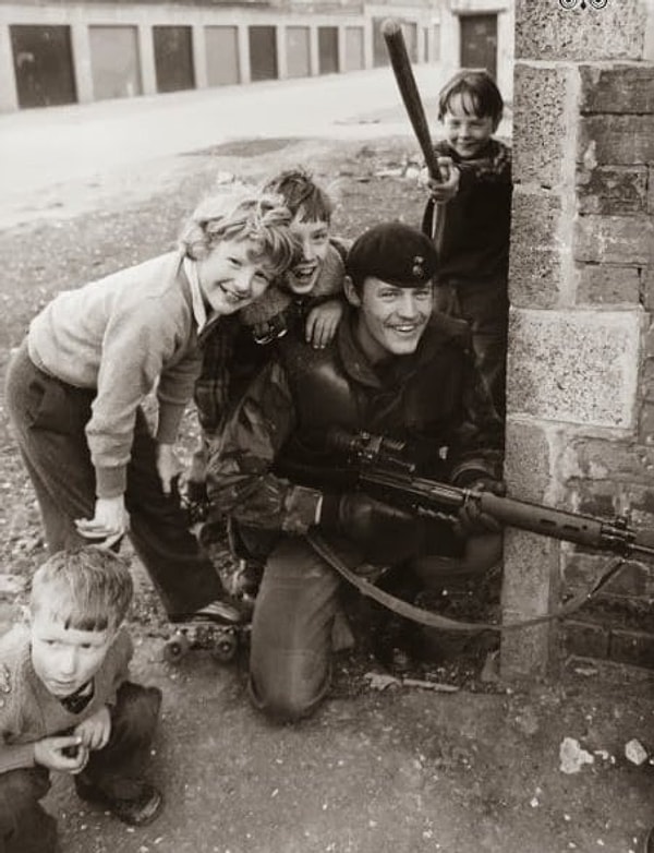 3. Британский солдат фотографируется с детьми во время патрулирования, Белфаст, Северная Ирландия (1981 года)