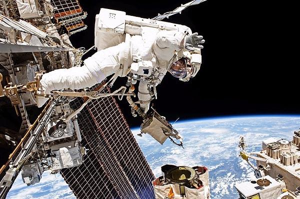 36. NASA astronotu Mark Vande Hei robotik kolun tamiratı sırasında kameraya el sallıyor.
