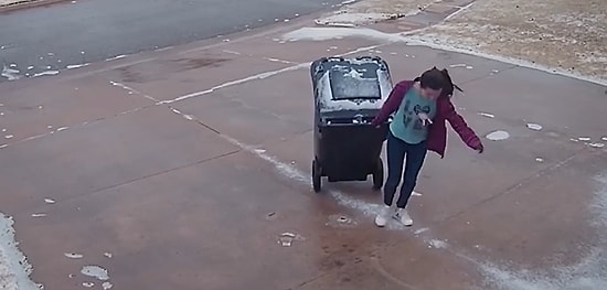 Çöp Çıkarmak Bazen Dünyanın En Zor İşi Olabilir: Buzlu Zeminde Çöp Kovasını İlerletmekte Zorlanan Genç Kadın