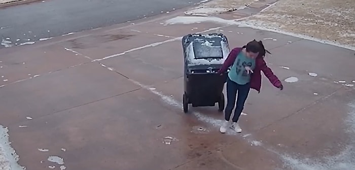 Çöp Çıkarmak Bazen Dünyanın En Zor İşi Olabilir: Buzlu Zeminde Çöp Kovasını İlerletmekte Zorlanan Genç Kadın