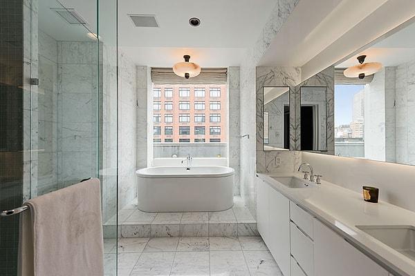 Evin en dikkat çekici yerlerinden biri de banyosu. Çift lavabolu tezgah, beyaz dolaplar, hem duş hem de küvet doğal mermer ile uyumlu.