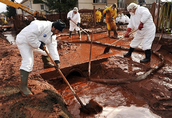 11. Macaristan'ın Kolontár köyünde 2010 yılında yaşanan selden sonra toksik derecede kirli çamurla dolmuş sokakları temizleyen belediye çalışanları.