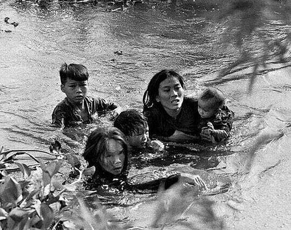 18. Vietnamlı bir anne, çocuklarını ABD’nin bombardıman yaptığı bölgeden kaçırmaya çalışıyor.