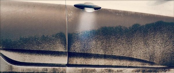 17. Дверь машины, на которой можно разглядеть инопланетную тарелку, зависшую над лесом