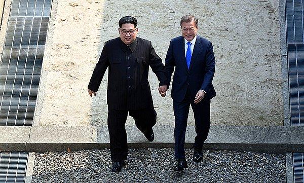 Kim Jong-un ile Güney Kore lideri Moon Jae-in, sınır hattında el ele kameralara poz verdi.