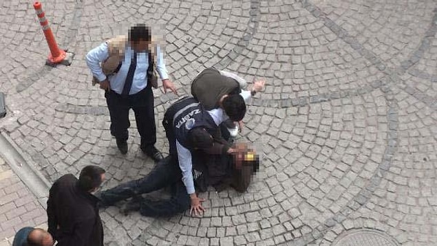 Zabıta memurlarından biri, kendilerine yardımcı olan kişiyle, yere düşen dilenciyi etkisiz hale getirmeye çalıştı.
