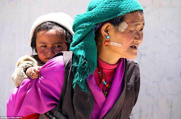 3. Xigazê, Tibet'te çocuğunu sırtında taşıyan bir anne, 2010.