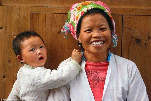 12. Yuanyang, Çin'de fotoğrafı çekilirken biraz şaşırmış görünen bir çocuk ve annesi.