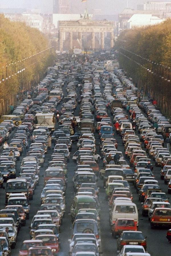 7. Berlin Duvarı'nın çöküşünden sonra Doğu Almanyalılar, Berlin'in batısına taşınırken Brandenburg Kapısı'nın oradaki trafik sıkışıklığı, 1989