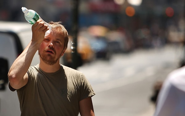 1. Мужчина пытается охладиться при помощи бутылки с водой во время жуткой жары в Нью-Йорке 9 июня 2008 года.