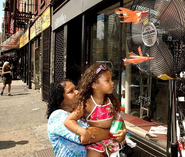 3. Мама с дочкой охлаждаются у вентилятора в Нью-Йорке в 2008 году.