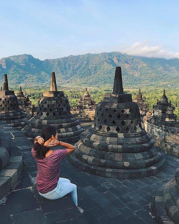 Bir gezgin Borobudur Tapınağı'nda manzaranın tadını çıkarıyor.