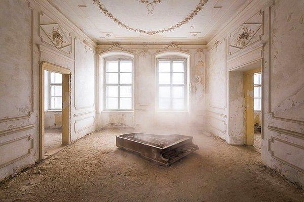 25. Terk edilmiş bir sarayın zemininde tozlar içinde bir piyano.