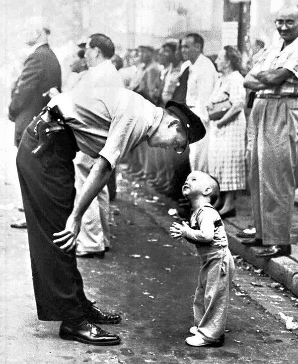 10. 1958 yılında bir polis memuru kibarca bir çocuğu geçit töreni varken karşıya geçmemesi için durduruyor...