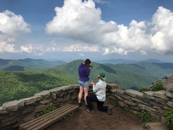 11. Парень делает предложение своей девушке на вершине горы.