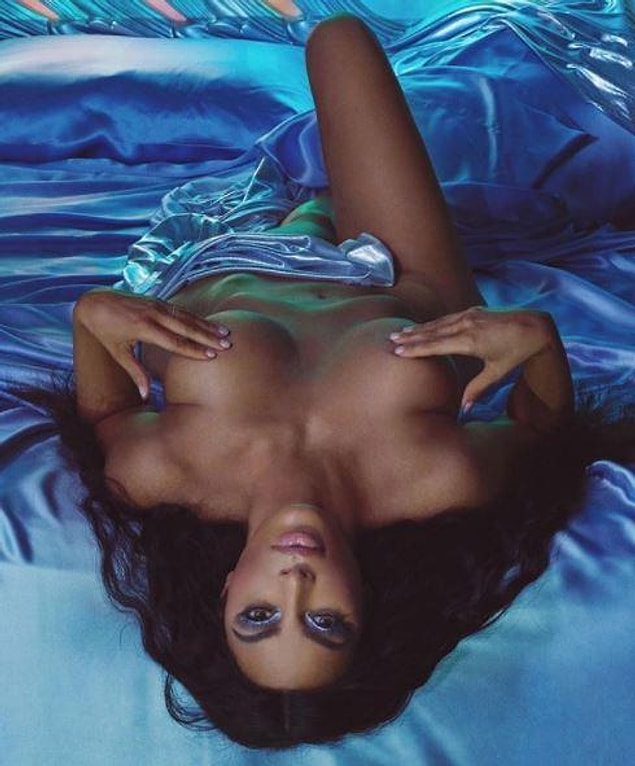 Kim placed her hands over her chest for extra modesty, while her head hung upside down off the side of the bed.