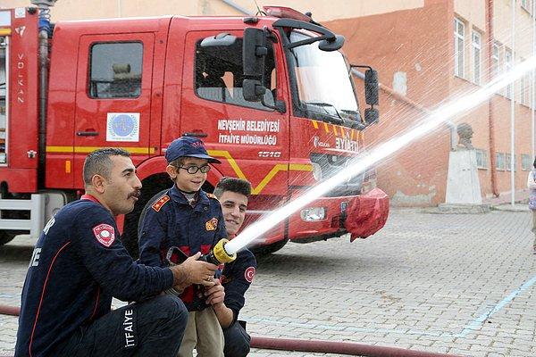 Okul bahçesinde yangın hortumunu kullanarak itfaiye personeli ile birlikte su sıkan Kerim’in mutluluğuna arkadaşları da eşlik etti.