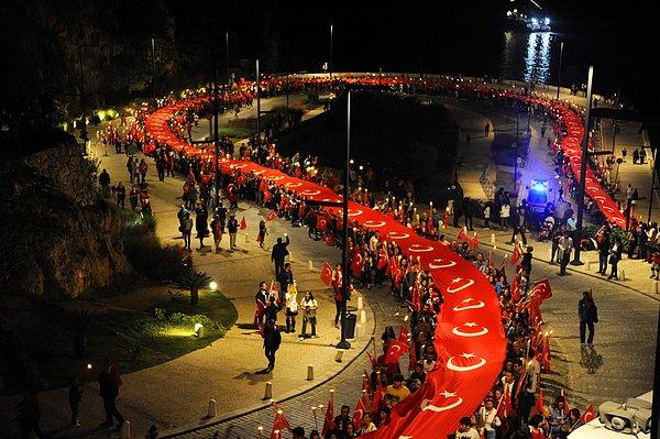 Antalya Konyaaltı Caddesi'ndeki varyantta bir araya gelen kalabalık, fener alayında yüzlerce metrelik bayrağı taşıdı