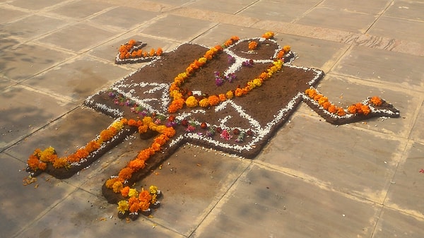 2. Коровьи лепешки перед ритуалом украшают оранжевыми цветами и перьями павлина.