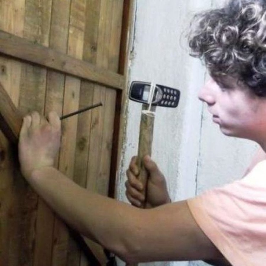 Молоток с Nokia 3310. Забить гвоздь. Парень забивает гвозди. Дверь с гвоздями.
