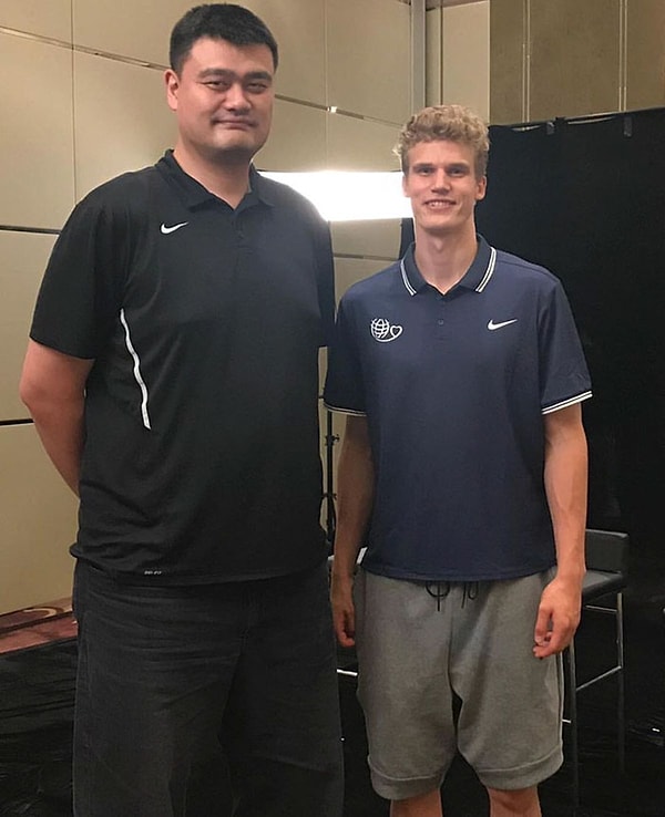 11. Яо Мин, китайский баскетболист, рядом с мужчиной, рост которого 213 см